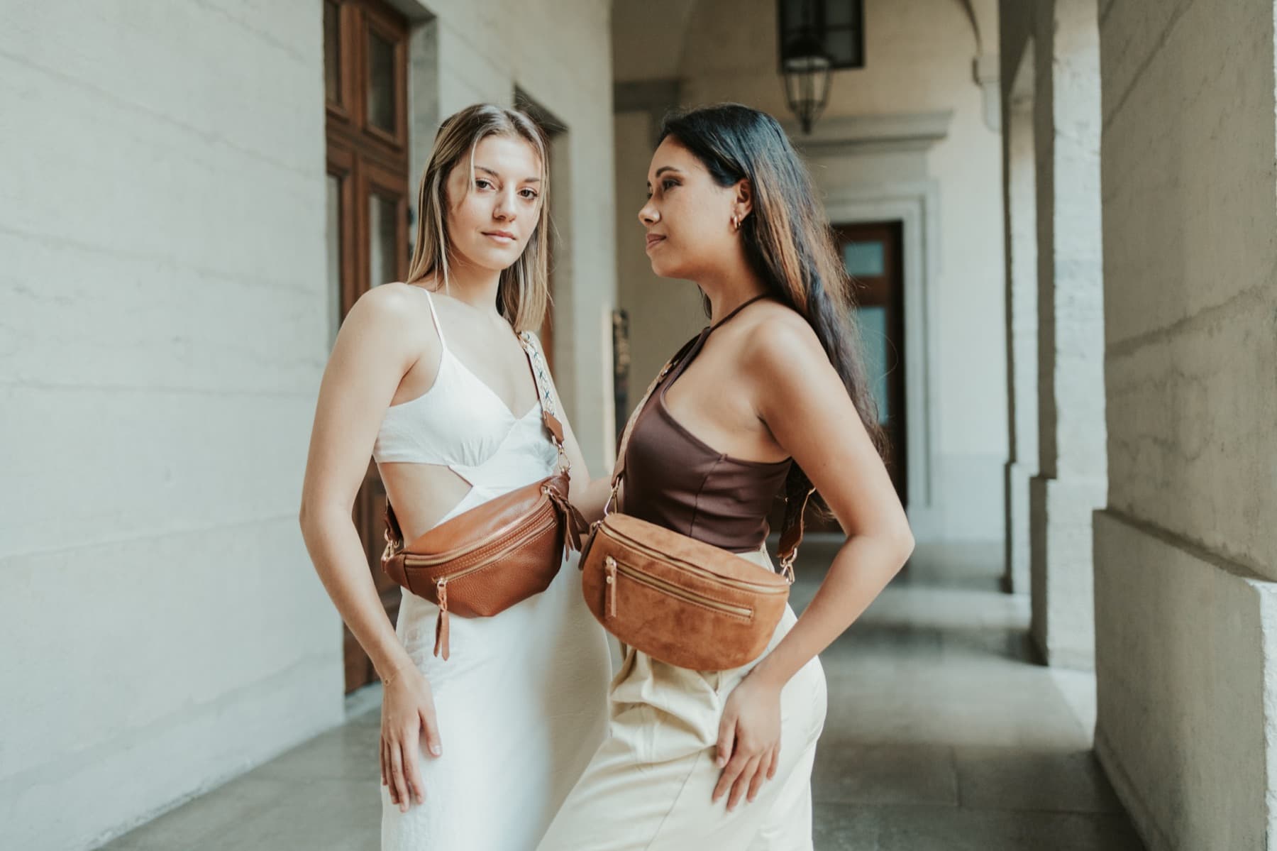 Duo de modèles présentant des sacs banane en cuir, arches